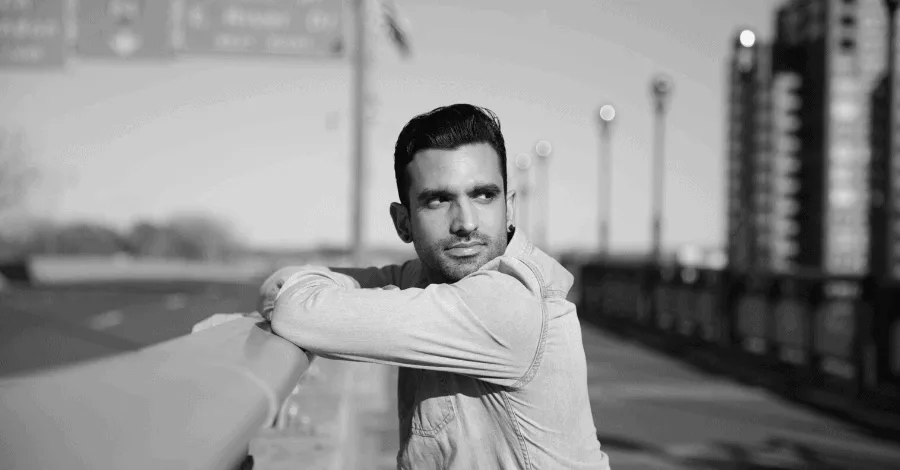 Flowaver in a denim shirt, black and white press portrait on a city bridge