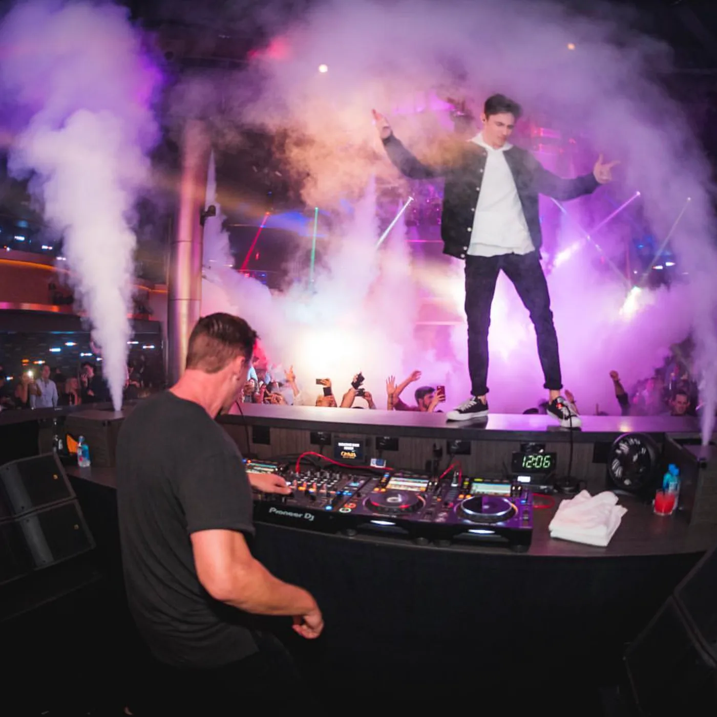 FOMO on stage with CO2 cannons firing, arms spread wide above the crowd