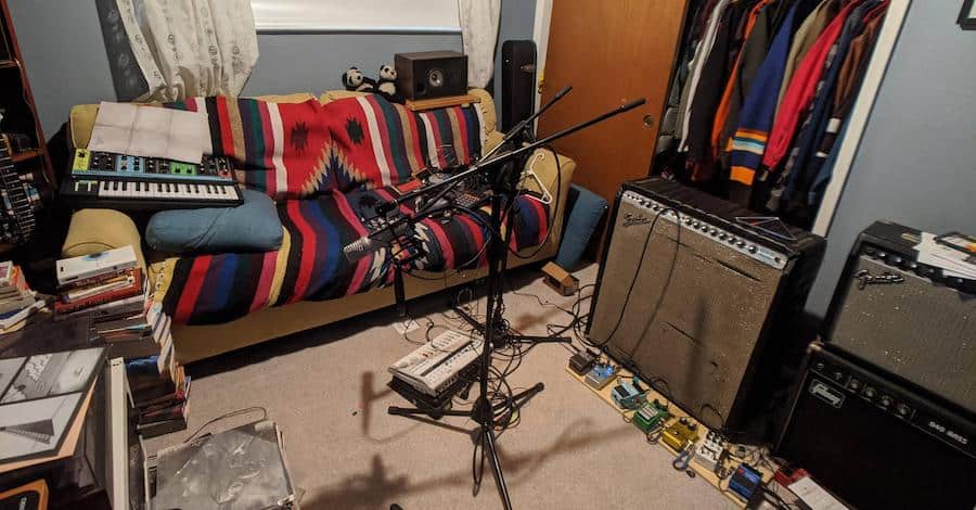 Imgur closet studio, stacks of books, colored blankets and guitar pedals making it warm and inviting