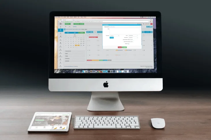 iMac on a wooden desk with a keyboard and mouse