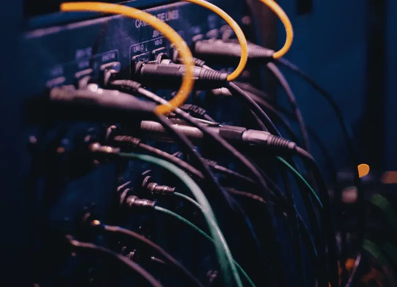 Patch cables plugged into the back of studio gear