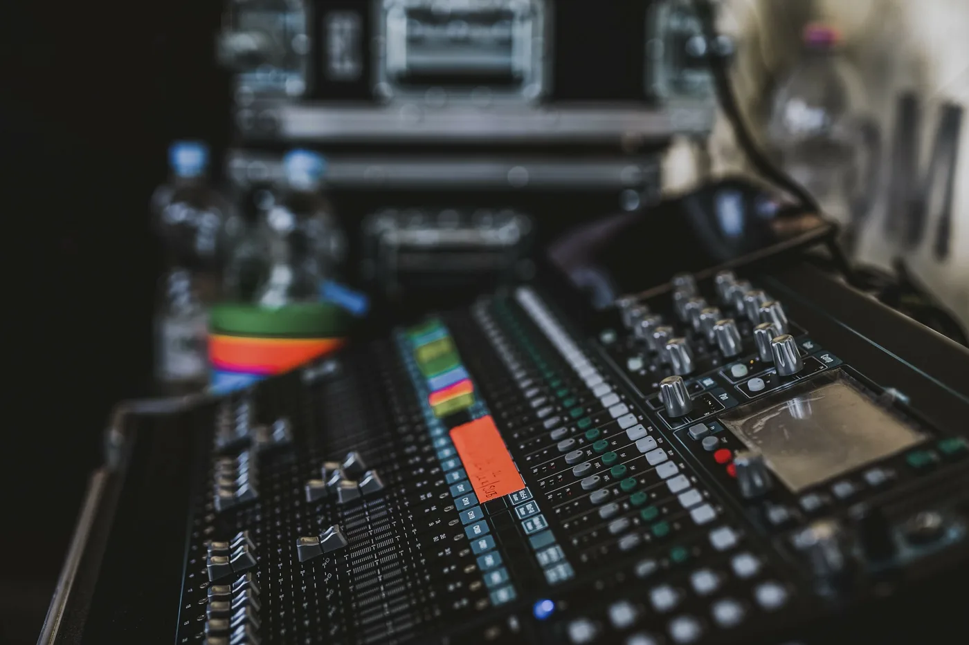 Close-up of an analog mixing console with faders and EQ knobs