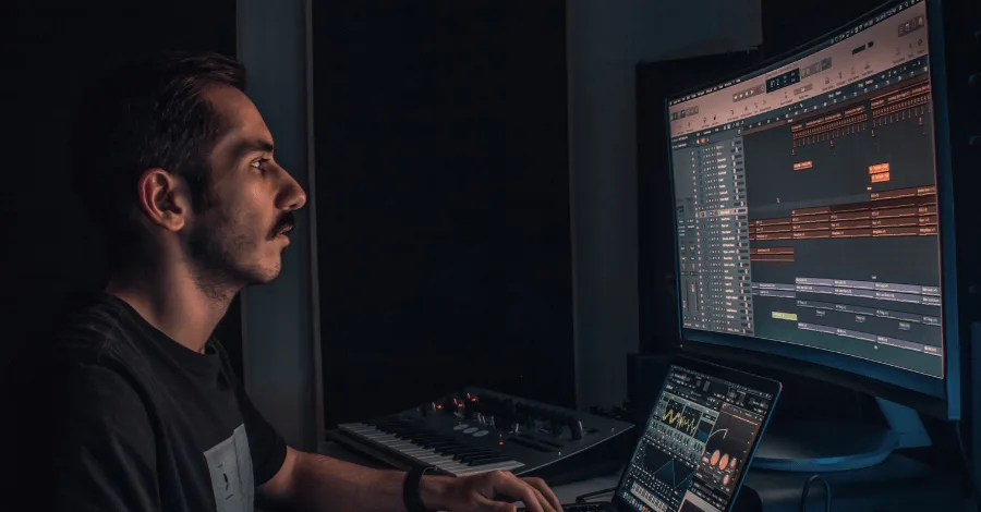 Home studio setup showing a MIDI keyboard, headphones, and a laptop running a DAW