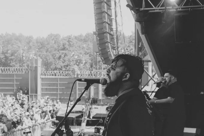 Artist performing on stage in front of a crowd, representing touring as an income stream