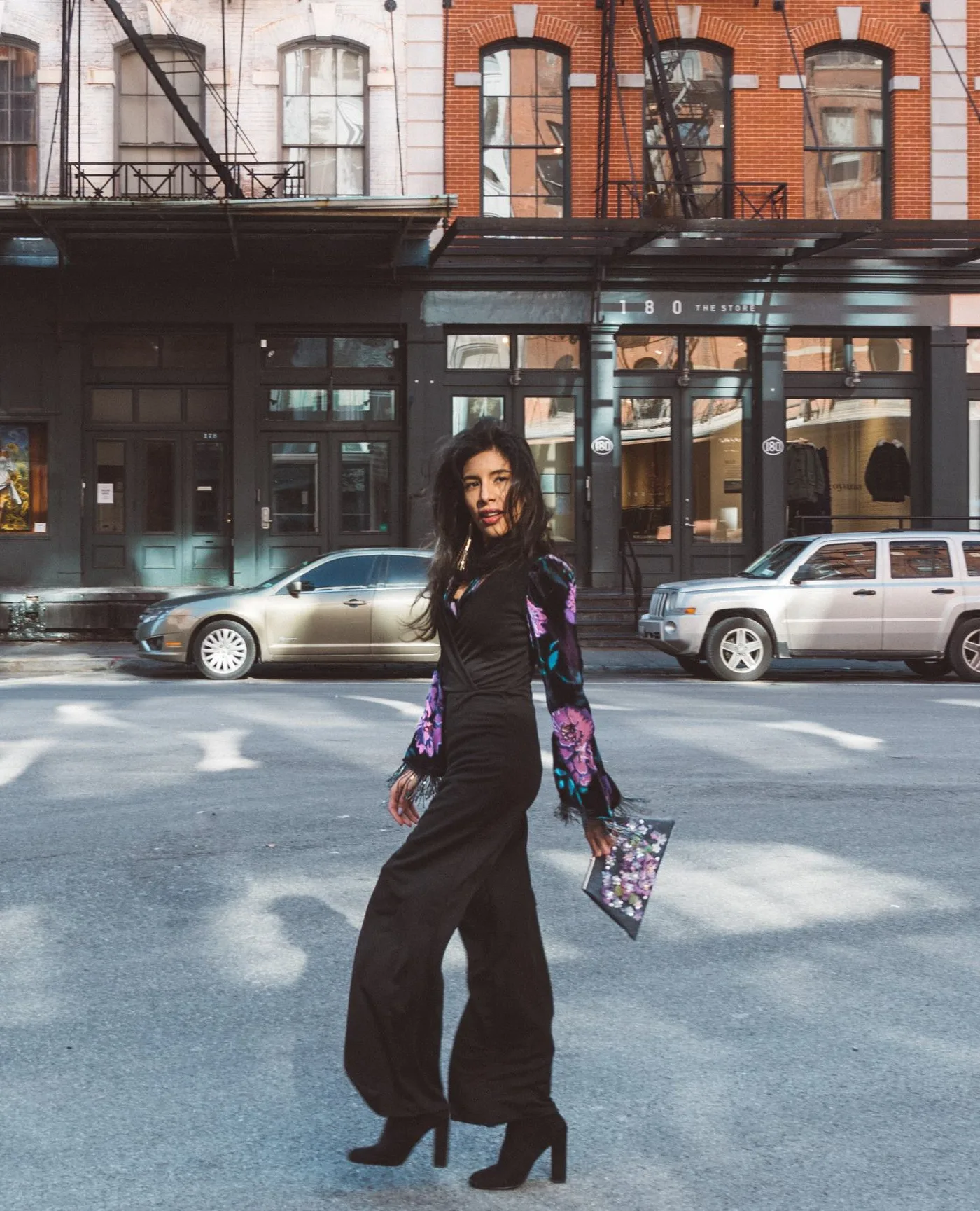 Ms. Unicorn in an editorial street style portrait, walking a downtown block in a long printed jacket