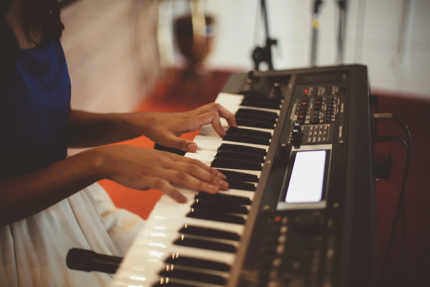 Woman playing piano in a studio, focused on composing