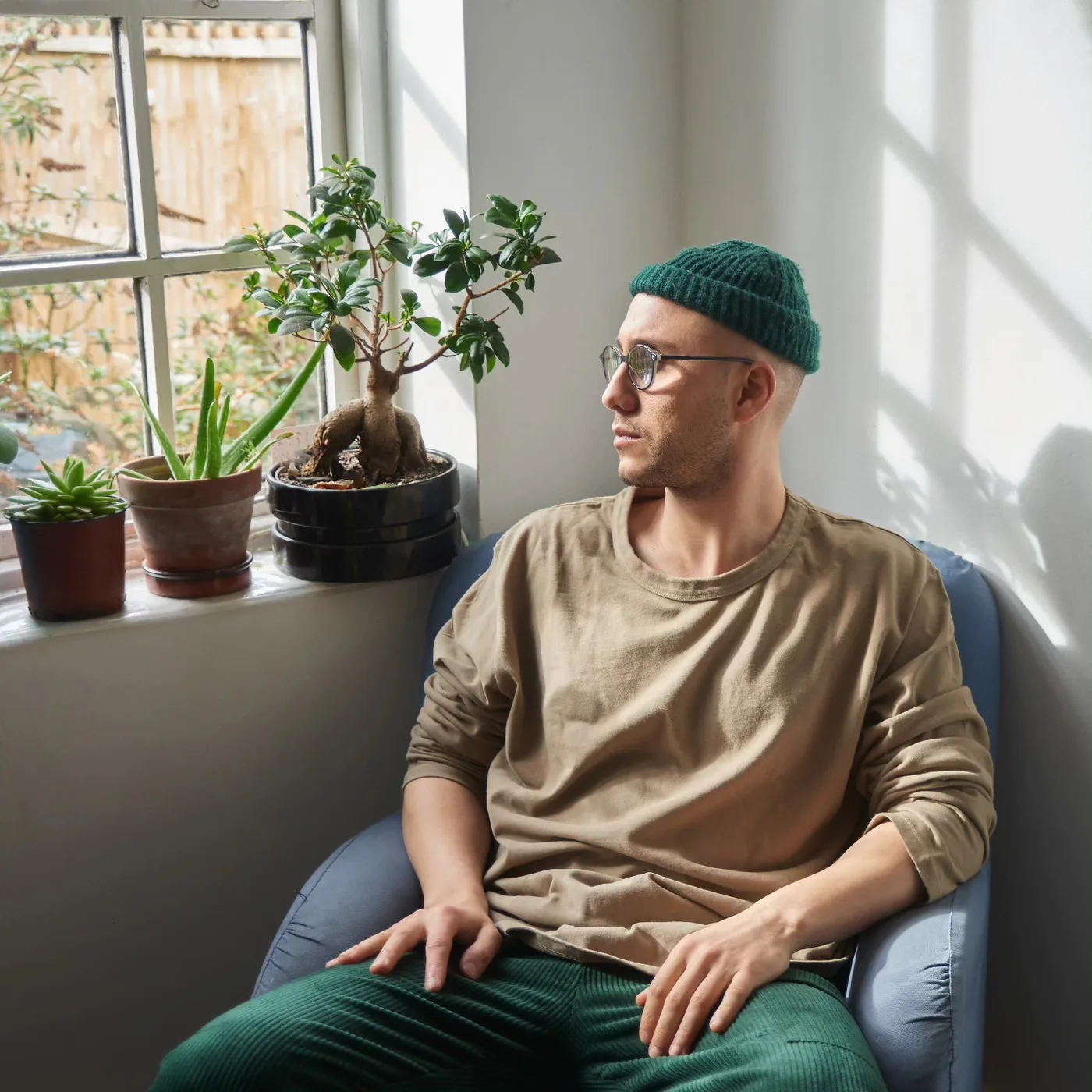 Sam Welch seated by a sunlit window, contemplative portrait