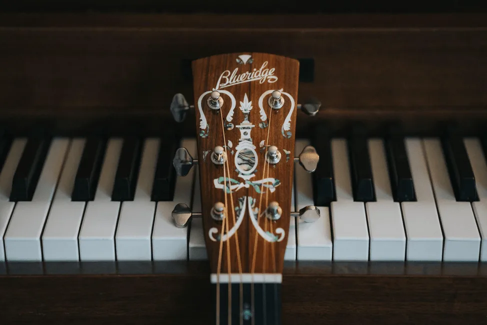 Guitar and piano keys side by side, representing the connection between composition and commitment