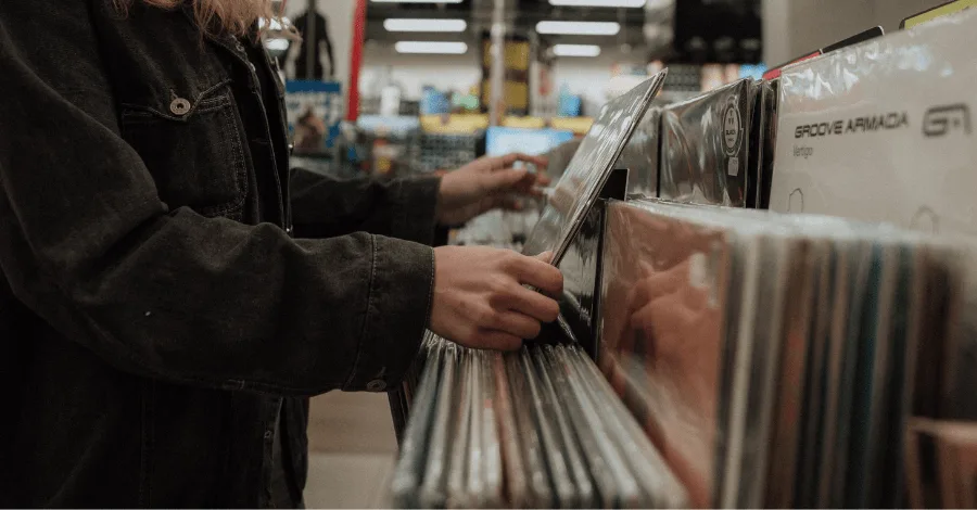 Person flipping through vinyl records at a record store