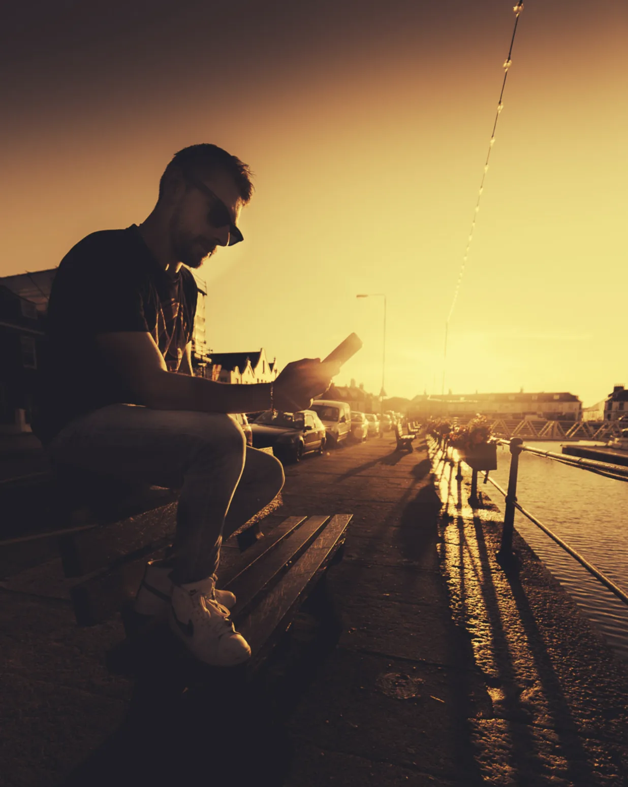 Josh Le Tissier in a moody silhouette by the water at golden hour