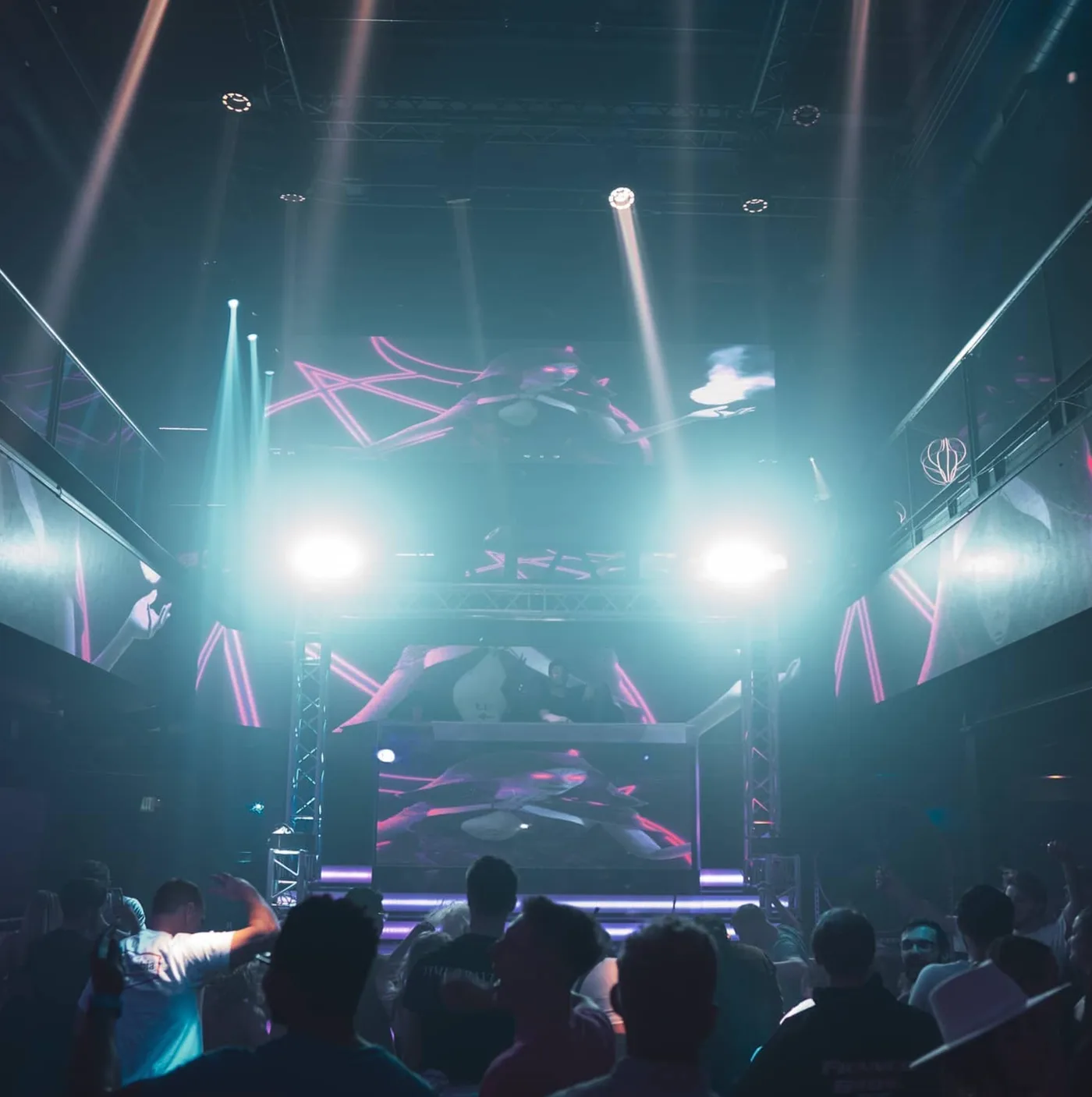 The Castle of False Light stage at BETA Nightclub in Denver, lit in pink and cyan with a full crowd in silhouette