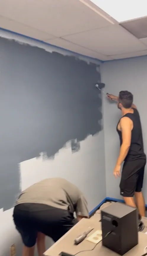 Painting the storage room walls dark grey during the build